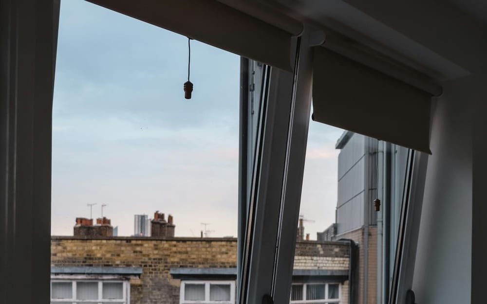 Roller blind above a tilted PVC window in a bedroom